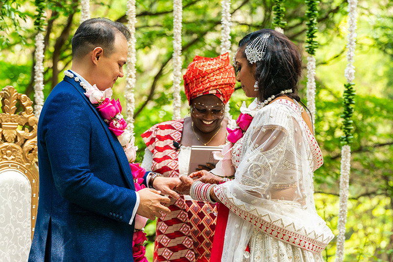 Wedding officiant marries bride and groom in a colorful festive outdoor wedding ceremony