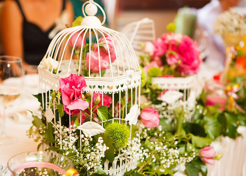 Birdcages with flowers for a bird theme wedding centerpiece