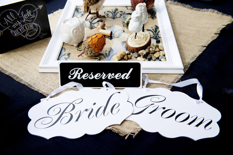 Upclose view of a sweetheart table wedding arrangement, with reserved sign and small bird candle holders