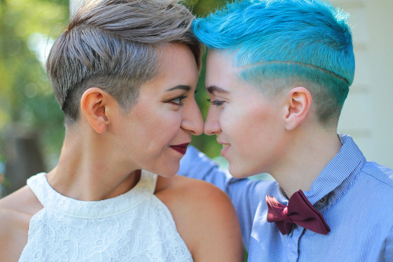 Two brides look at each other happily on the wedding day, posing for the photographer
