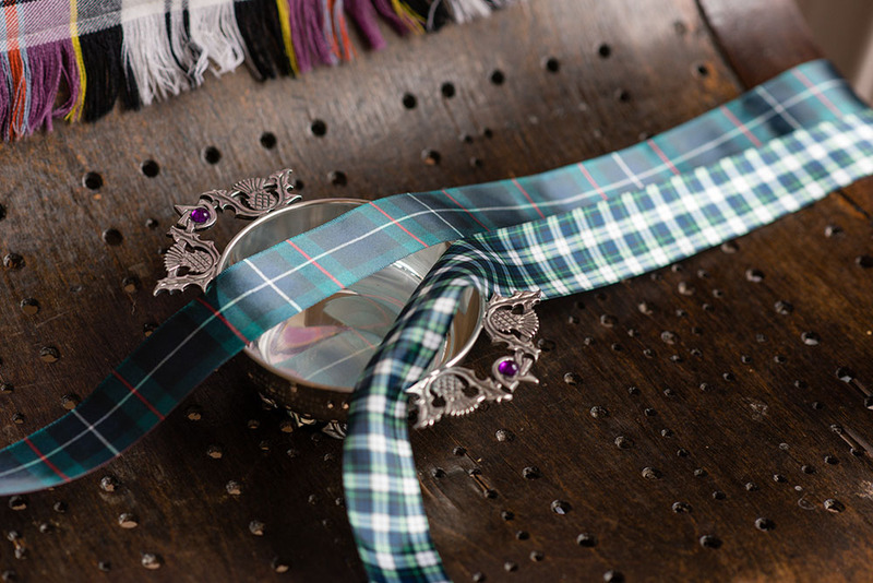Close up of a decorative silver wedding quaich and a tartan ribbon for handfasting