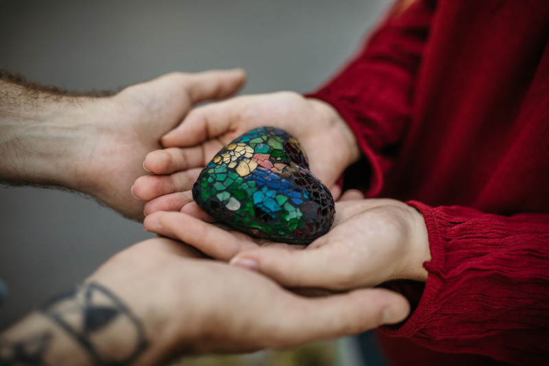 Couple holding a colorful shiny oathing stone during their wedding ceremony