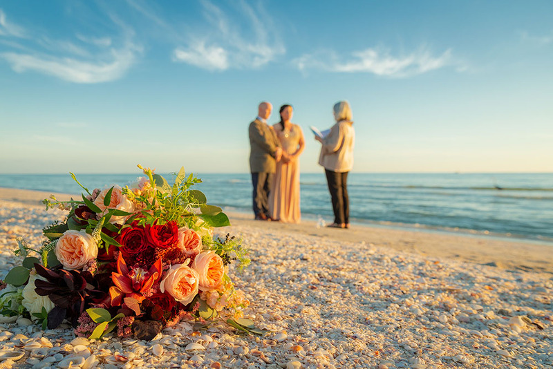 Bride and groom elope on the beach with their wedding officiant