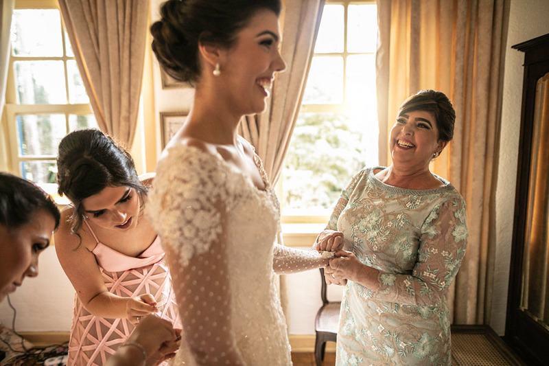 Bridesmaids and mother of the bride help the bride get ready on the wedding day. everyone is happy and smiling