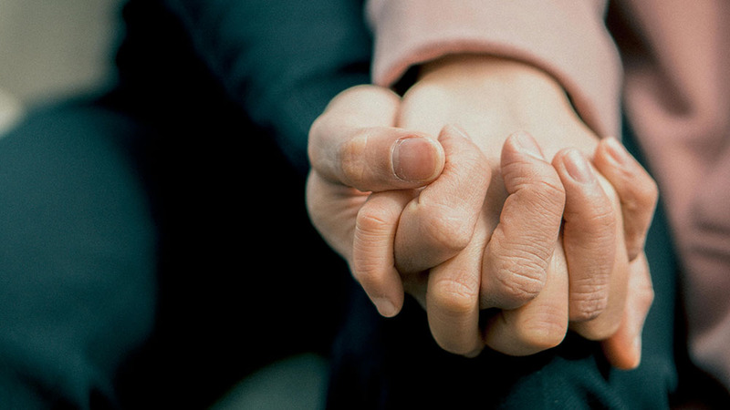 Close up of two people holding hands lovingly