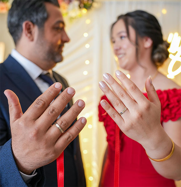 bride and groom show off their new wedding rings