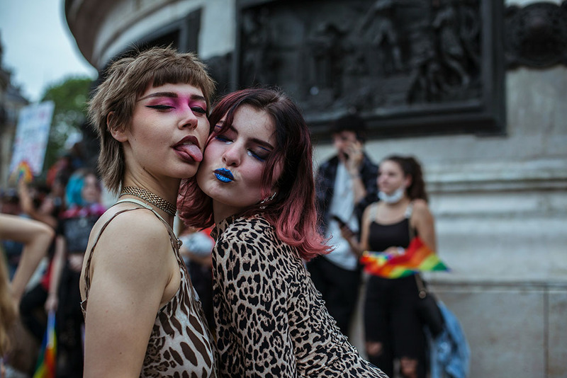 Two women pose at a pride event making sweet and silly faces