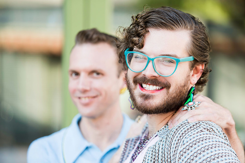 Two genderfluid people smile at the camera
