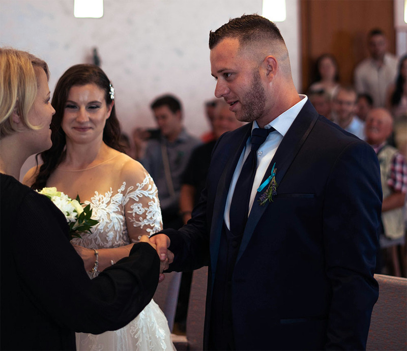 La novia y el novio están con el oficiante de la boda durante la ceremonia.