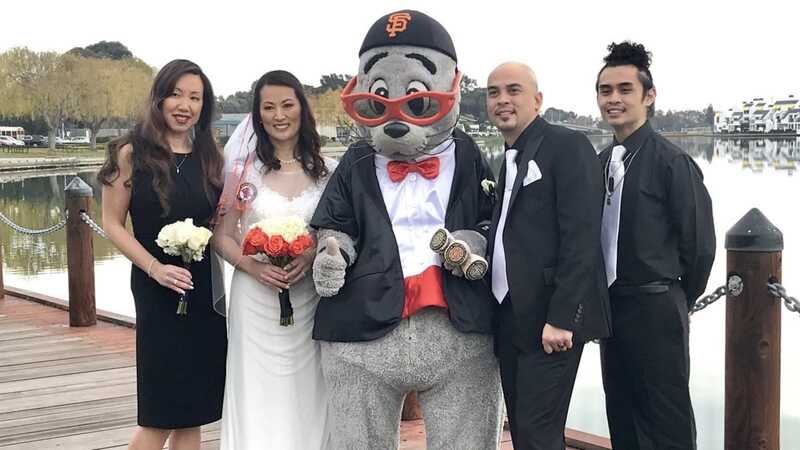 Giants mascot Lou Seal poses with the bride and groom and friends on the wedding day after officiating the ceremony