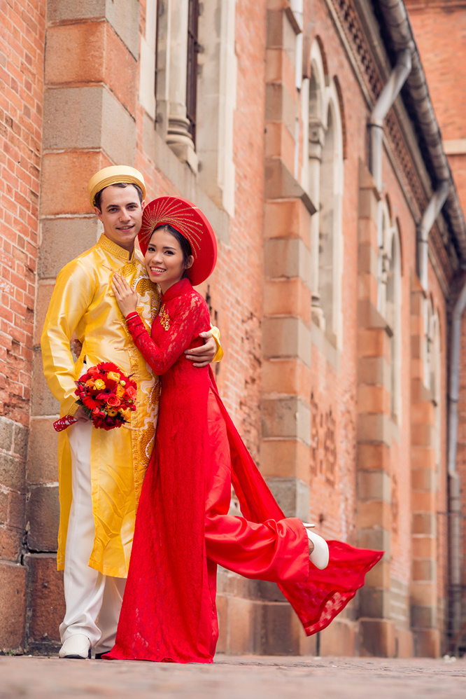 Bride and groom pose in traditional Vietnamese wedding clothes