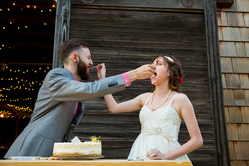 Groom and bride feed each other a bite of cake using forks during the reception