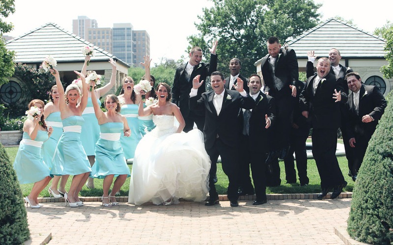 A bride and groom pose with the wedding party, including 7 bridesmaids and 9 groomsmen