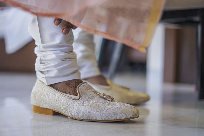 Close up of Indian groom in white wedding shoes