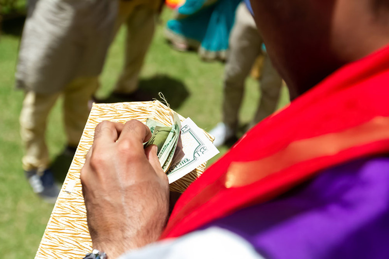 A groom looks at an envelope of money, the ransom for his shoes! 