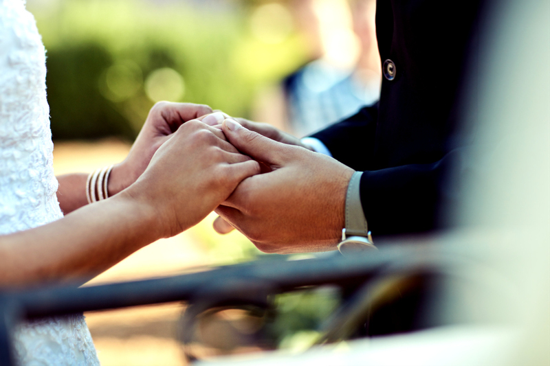 La novia y el novio se toman de la mano durante una ceremonia de boda