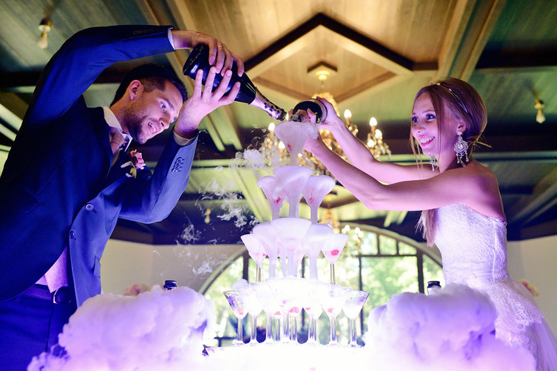 newlyweds pour champagne in a tower of coup glasses