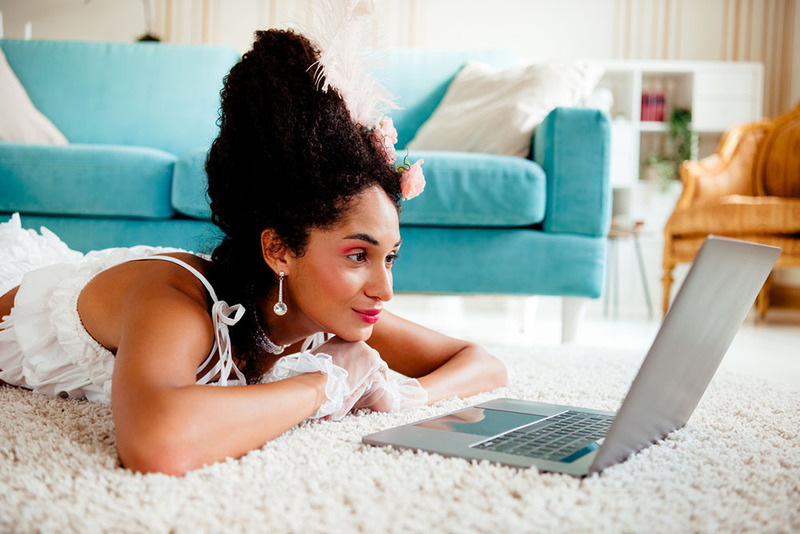 Young woman looks at website, dressed in glamorous outfit