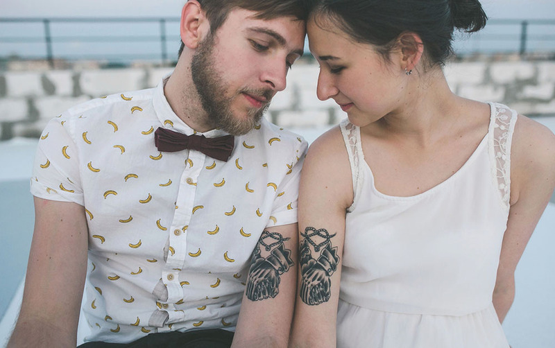 young gen z bride and groom pose with matching wedding tattoos