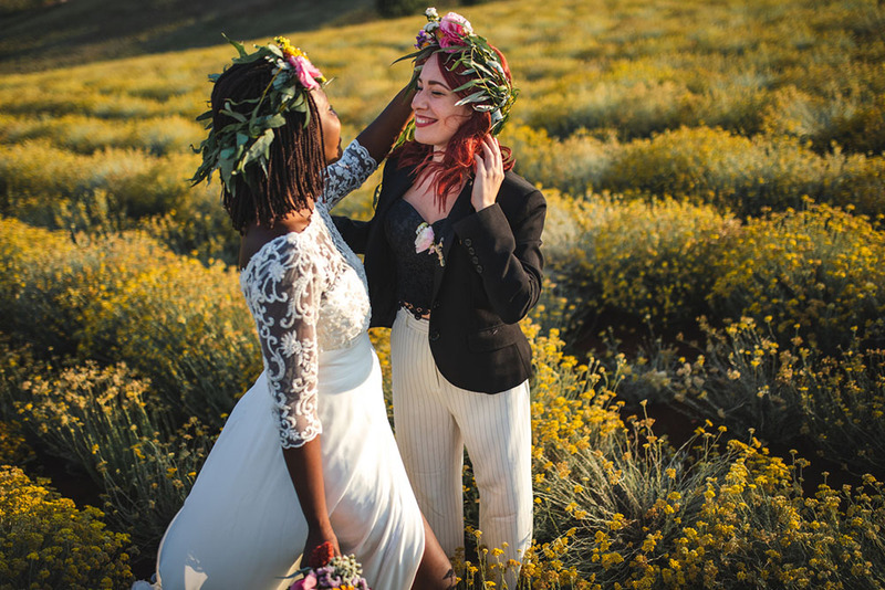 Brides pose in a colorful field in their wedding dresses