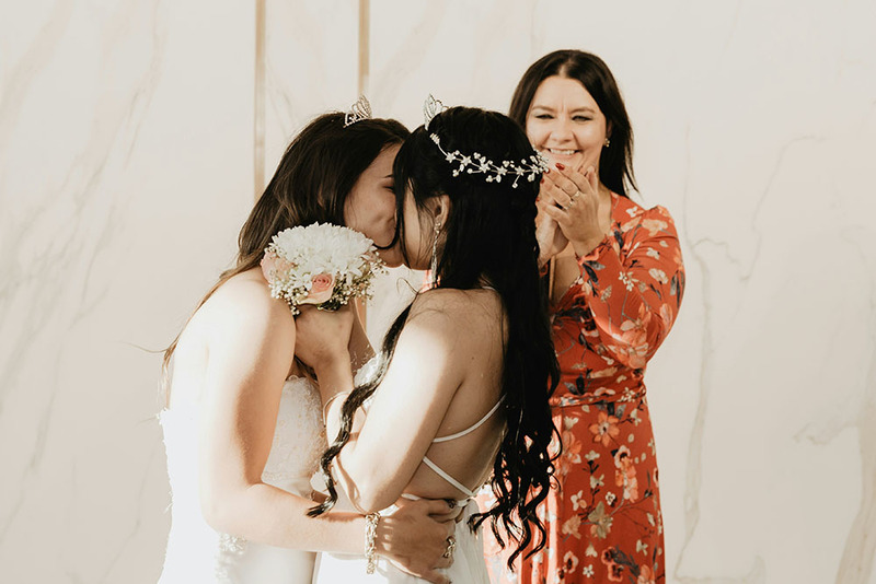 A wedding officiant performs a wedding for two beautiful brides