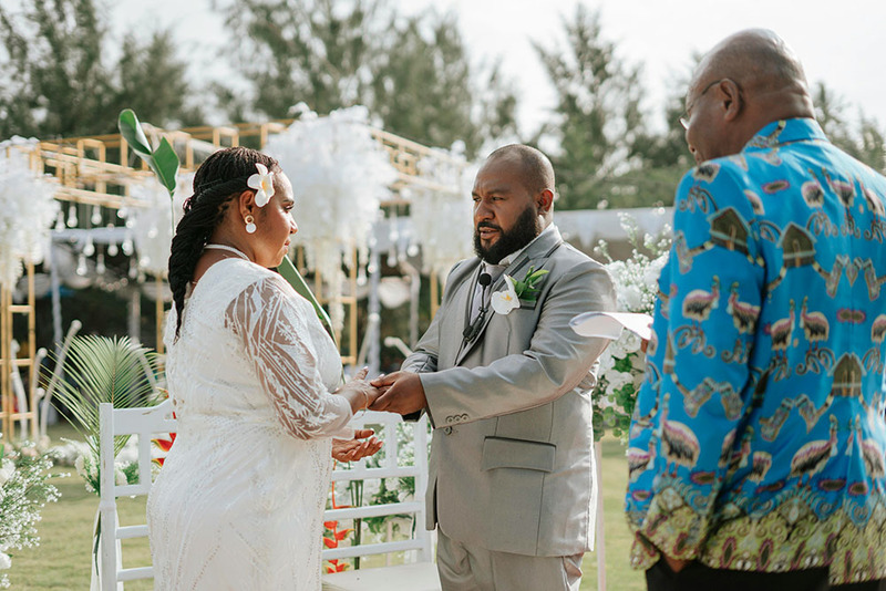Couple get married outdoors with wedding officiant on sunny day