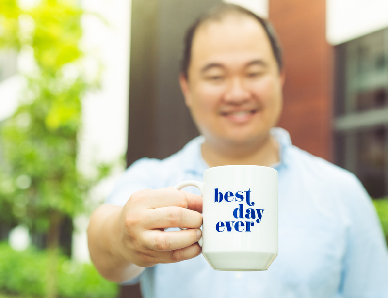 Wedding officiant holding up a "best day ever" mug