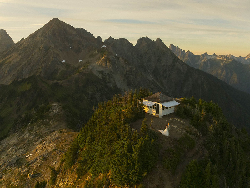 Bride and groom in aerial photo of mountains