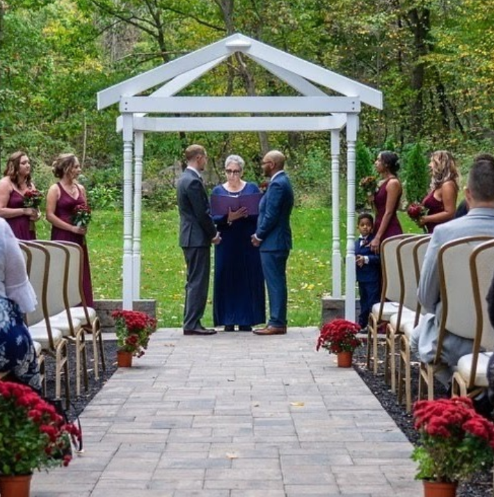 Officiant Lori performs an outdoor wedding for two happy grooms