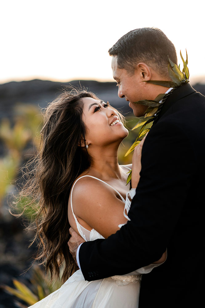 happy newlyweds embrace while eloping in hawaii