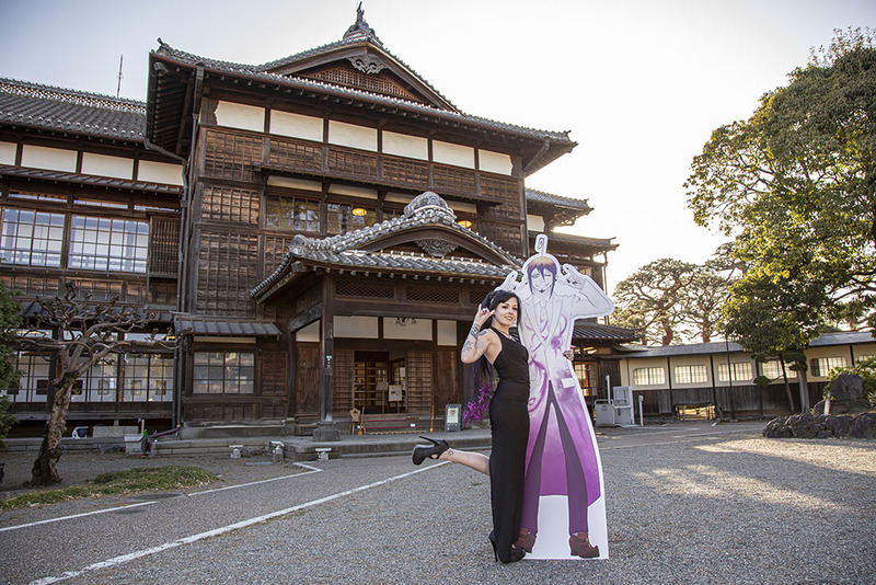 Dis Pheles poses with a custom cut-out of Mephisto following their symbolic ceremony in Japan