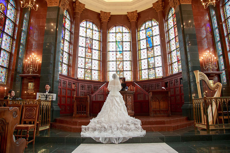 bride stands with a wedding officiant in an ornate church during a symbolic 2d wedding