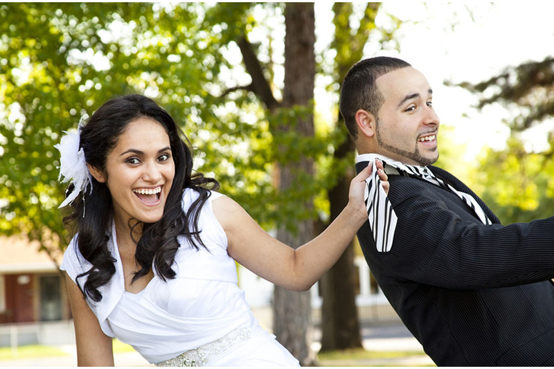 bride pulls on grooms tie playfully 
