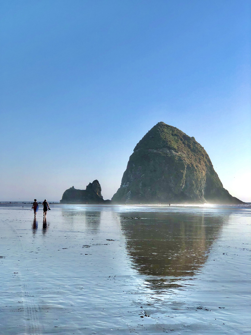 couple walking along the cannon beach shore