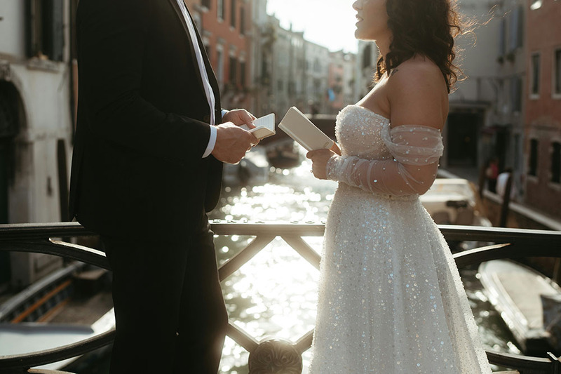 close up, bride and groom holding vow booklets reading wedding vows