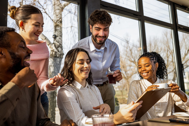 Couple singing the marriage license for a lavender marriage ceremony, with friends as witnesses in casual ceremony over coffee