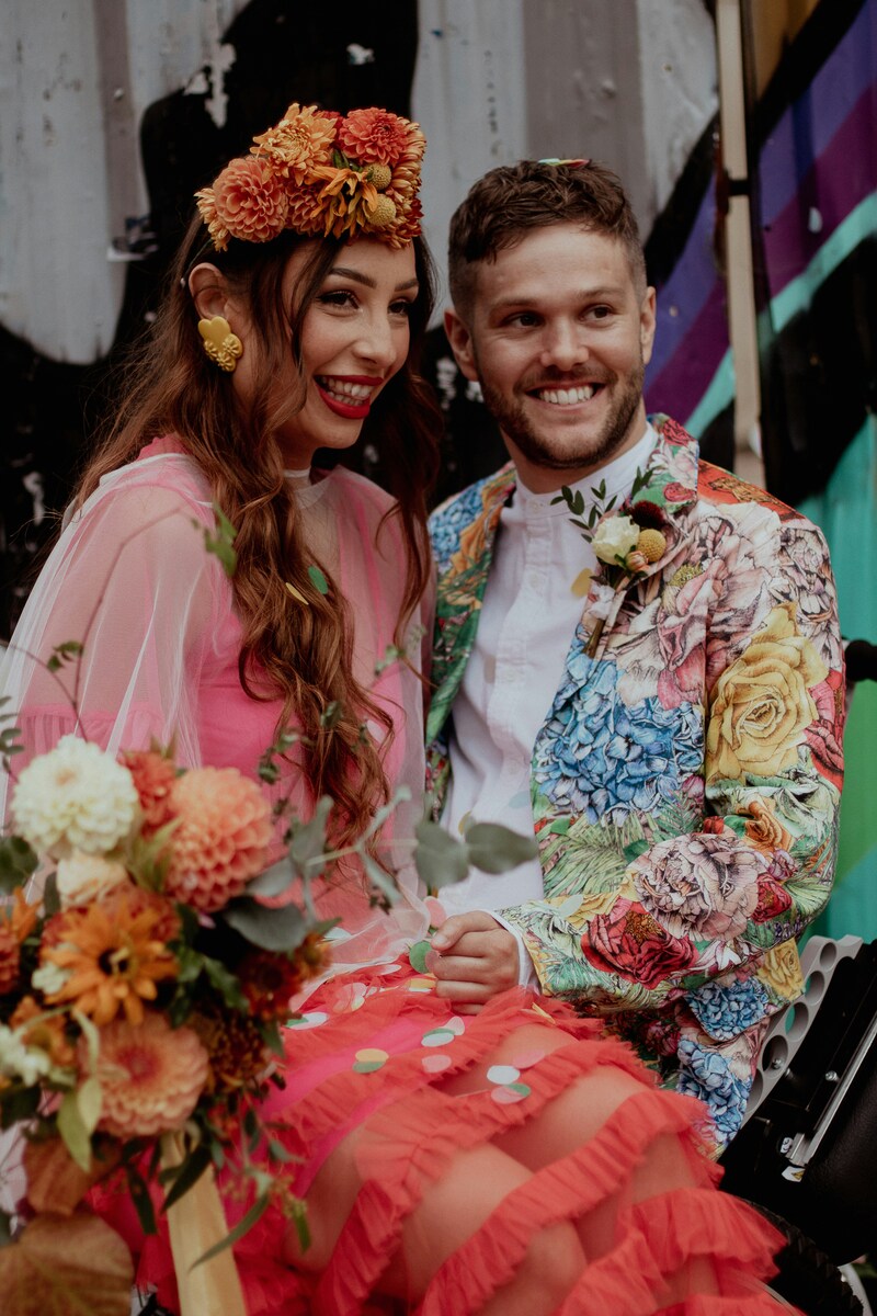 Colorful bride and groom pose on wedding day