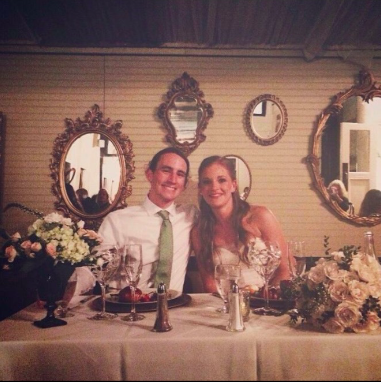 image is a photograph of Emily and Aaron O'Neill on their wedding day, smiling at the camera