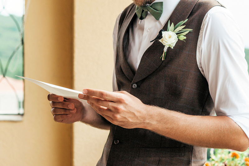 image of groom holding a wedding ceremony script, wedding traditions and planning