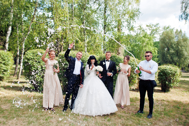 a happy group celebrate a group wedding elopement outdoors with a toast of champagne and laughter