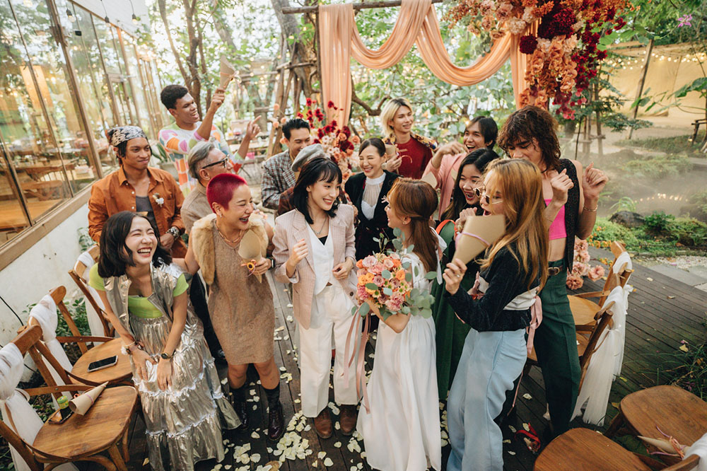 A large happy lesbian wedding outside with friends and family