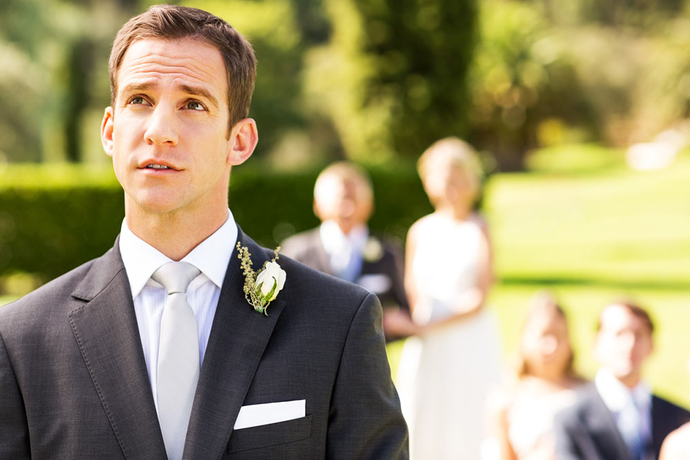 Nervous grooms looks up in thought during wedding ceremony