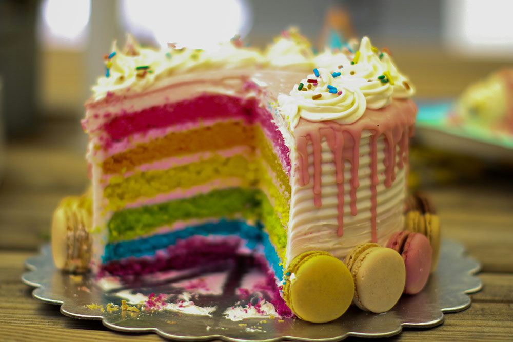 Rainbow layer cake with macrons, festive birthday cake