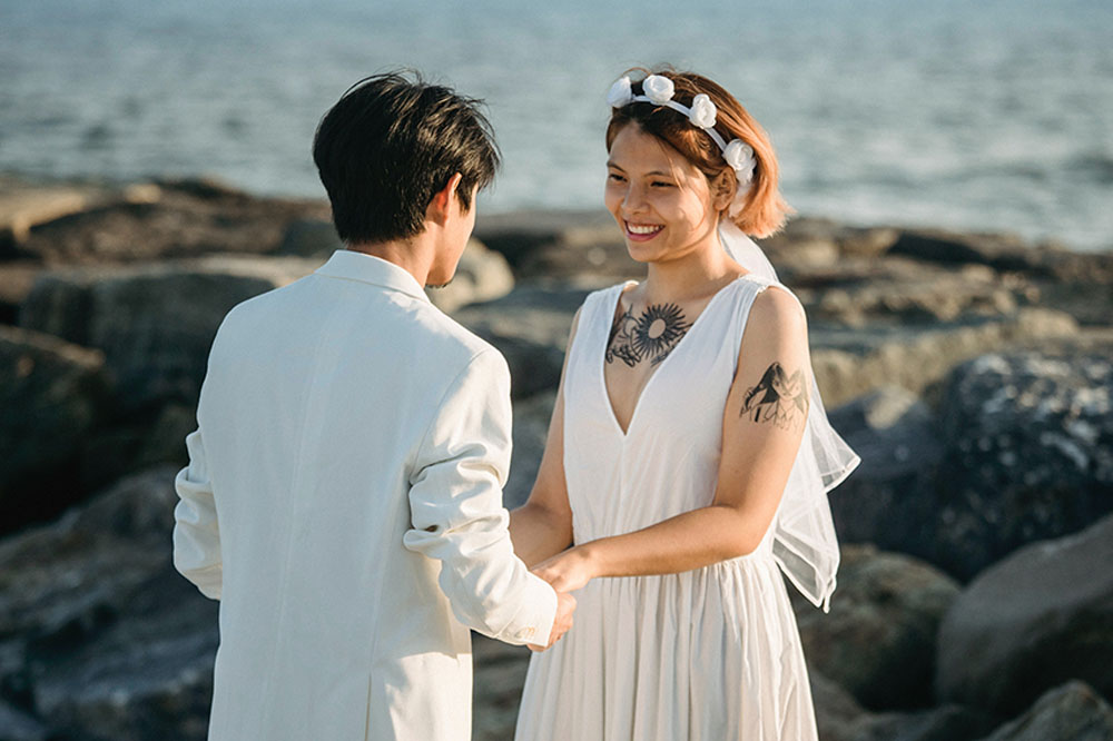 Los novios se toman de la mano durante una boda en la playa.
