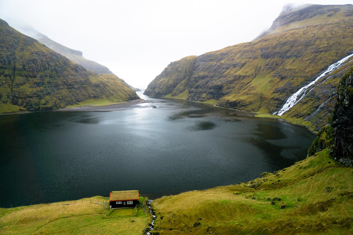 Chris Burkard photo of small mountain cottage next to alpine lake