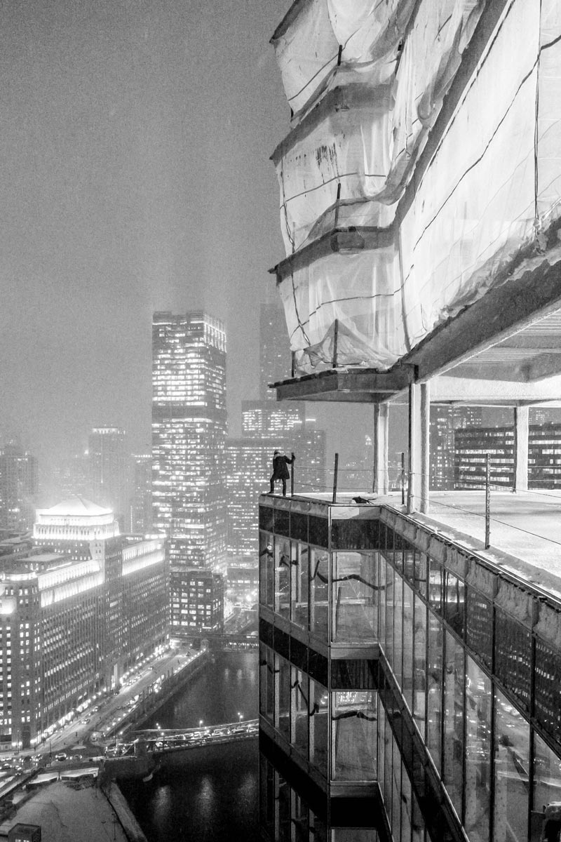 Photo of person standing at the edge of a skyscraper under construction by Jason Peterson