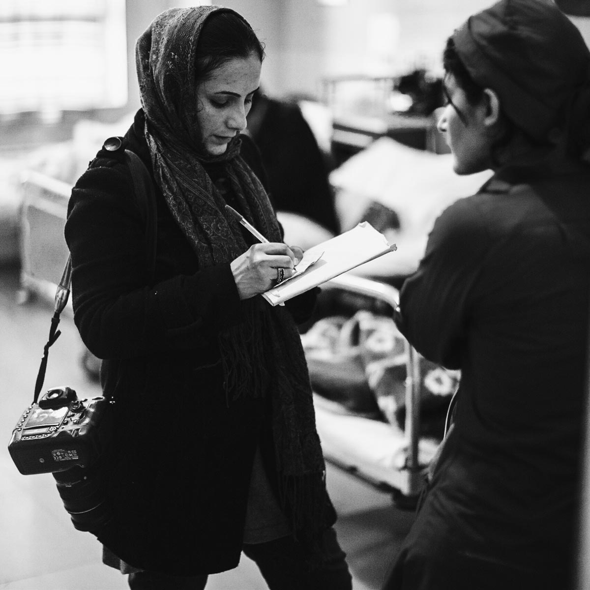 Woman speaking to another woman while taking notes