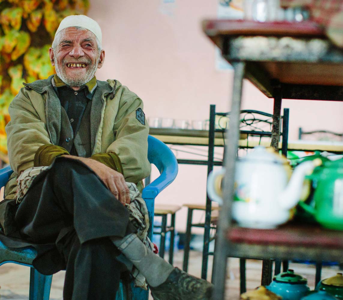 Older gentleman sitting in a chair smiling