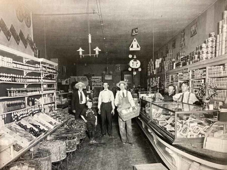 The Blackfoot Grocery Store inside from about 1907, with 6 people staring at the camera.
