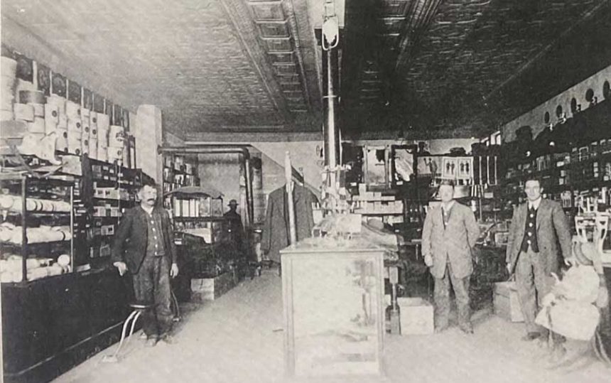 Inside of Dye Mercantile store with three people, circa 1925.